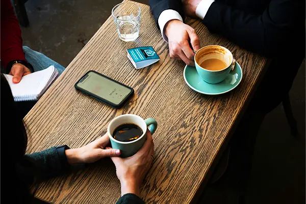 Deux personnes échangeant autour d’une table